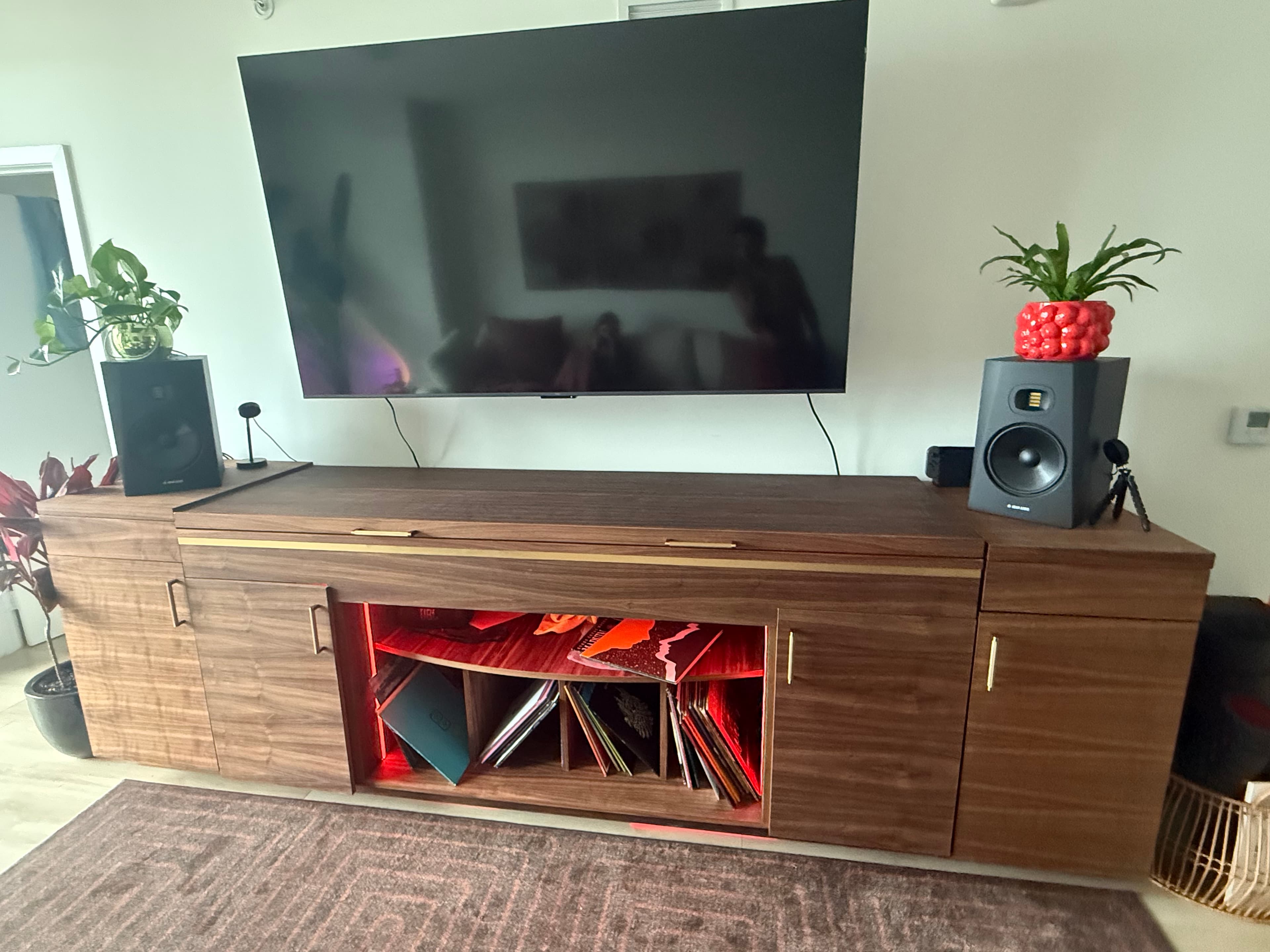 Bespoke walnut media console with brass inlay and integrated RGB-lit record storage