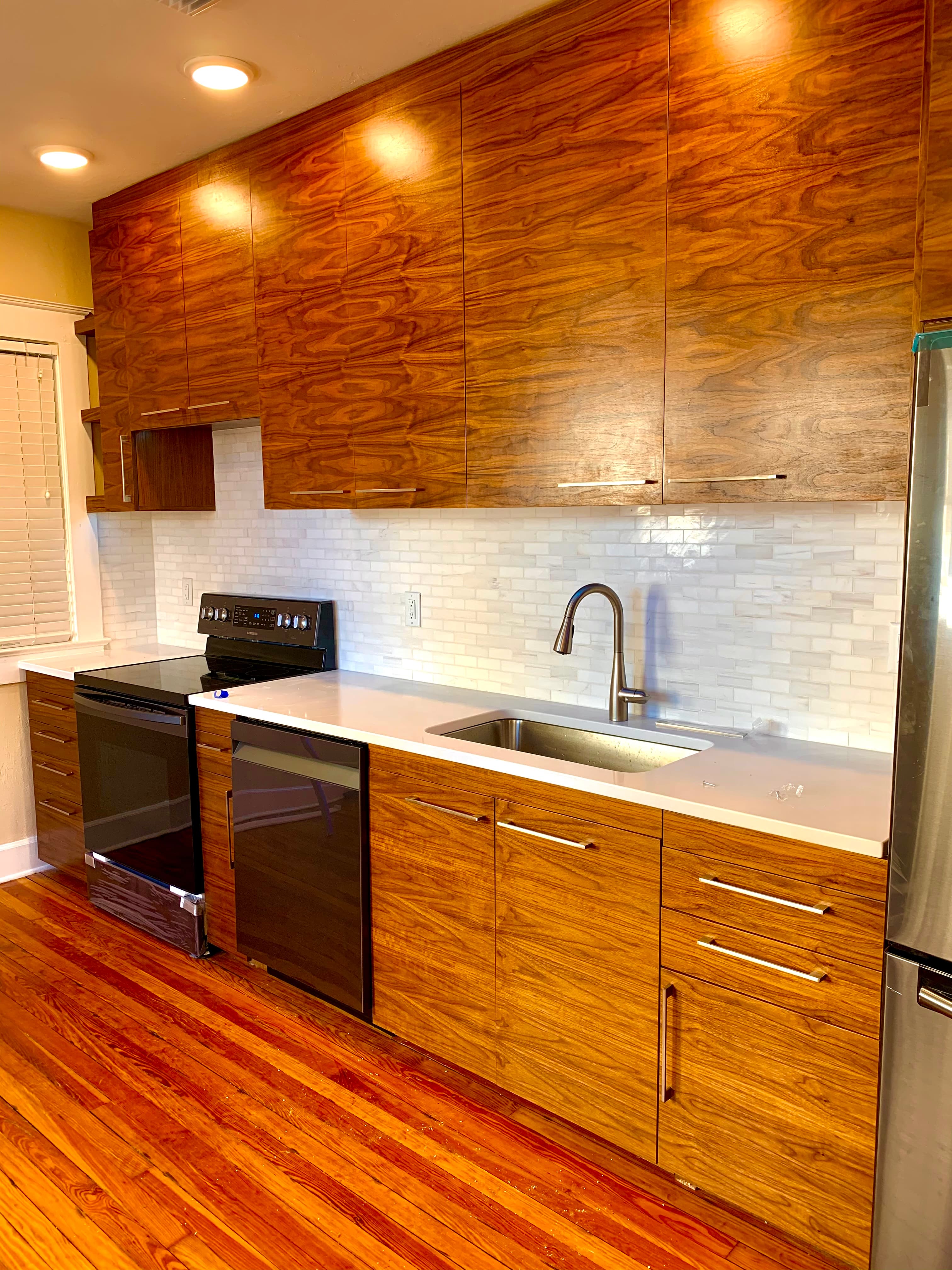 Wood slab-front kitchen with integrated machined pulls and stainless appliances