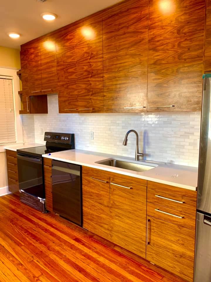 Full-height storage wall in wood over a clean white backsplash