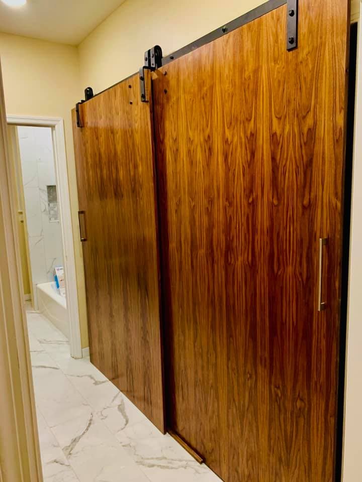 Wood sliding barn doors acting as a room divider on exposed track hardware