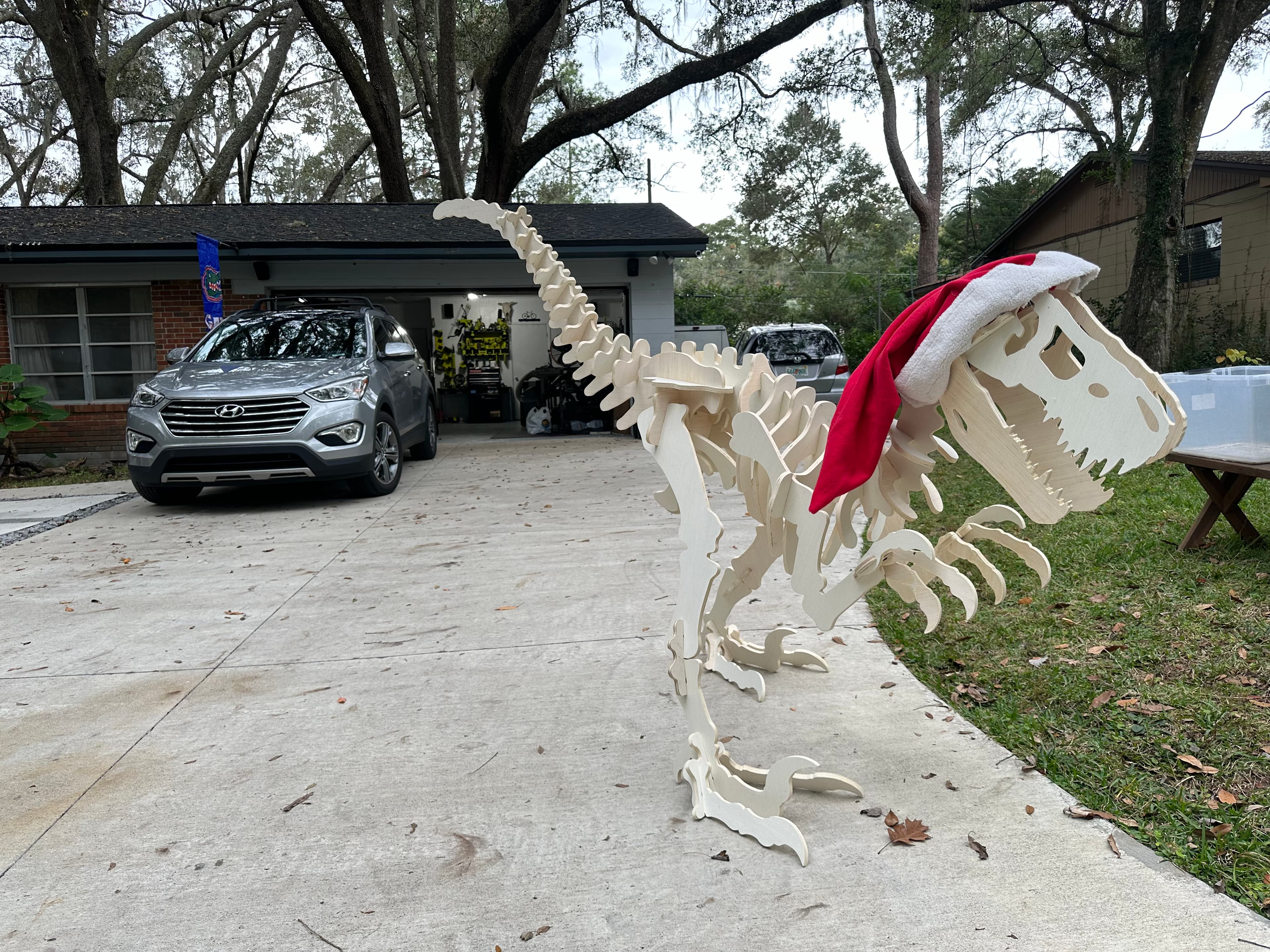 Large slot-together raptor skeleton built from interlocking CNC-cut birch plywood ribs, standing outdoors