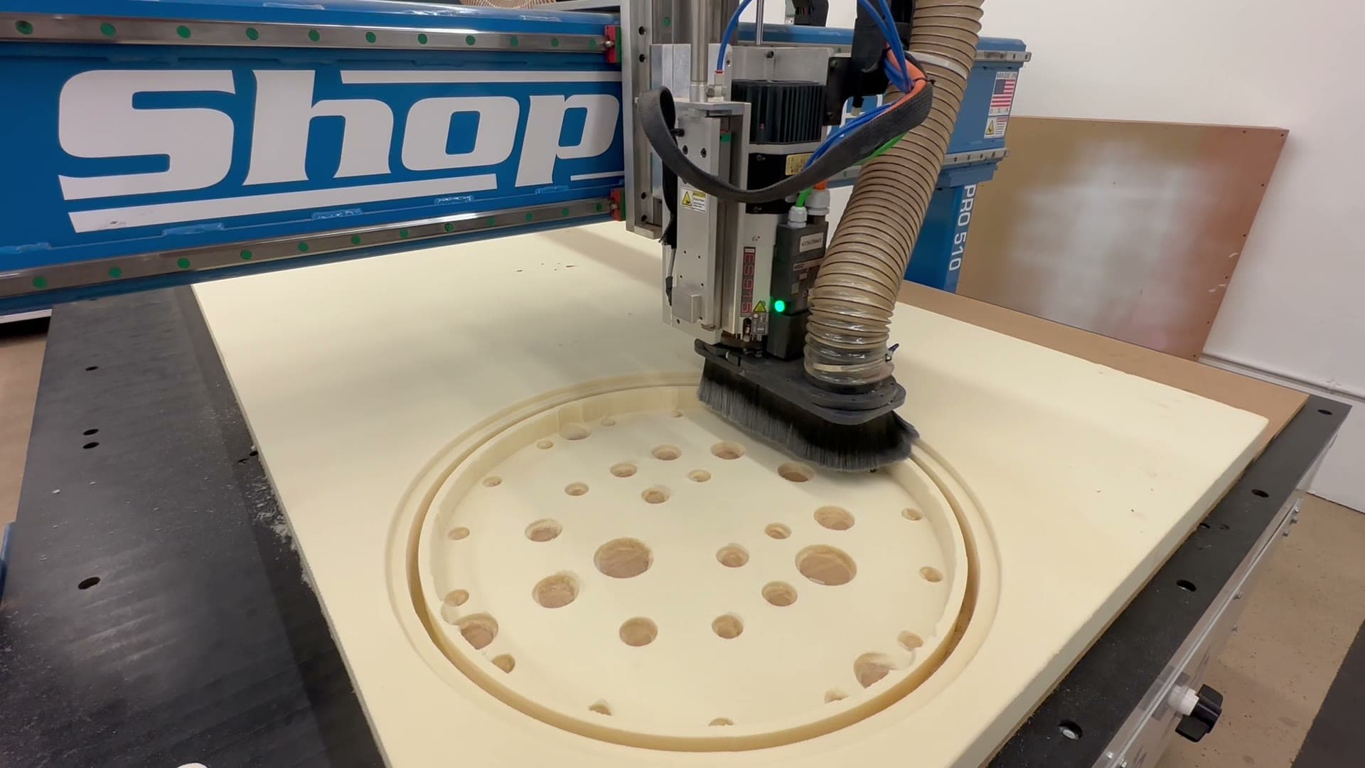 The CNC cutting a circular geometric pattern into a panel for a screen